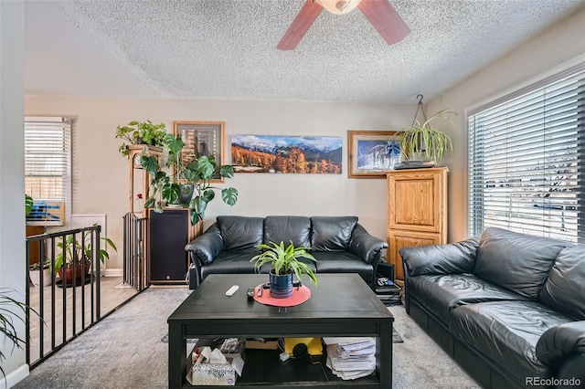 carpeted living room featuring ceiling fan, a wealth of natural light, and a textured ceiling