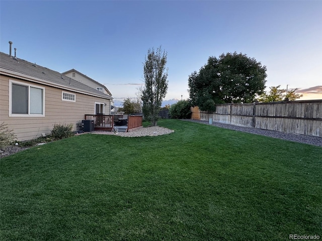 yard at dusk featuring a deck and central air condition unit