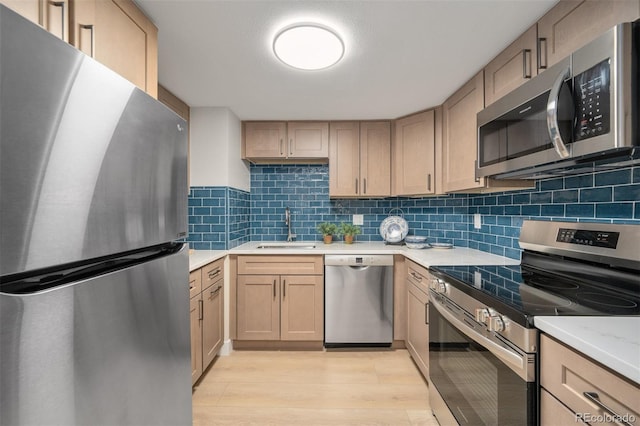 kitchen featuring light brown cabinetry, sink, and stainless steel appliances