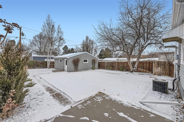 snowy yard with an outbuilding and central AC unit