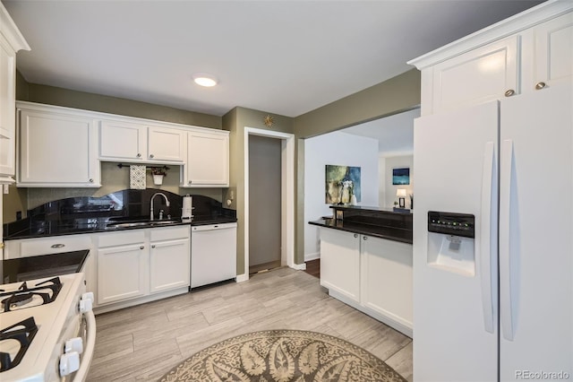 kitchen with light hardwood / wood-style floors, white cabinetry, white appliances, and sink