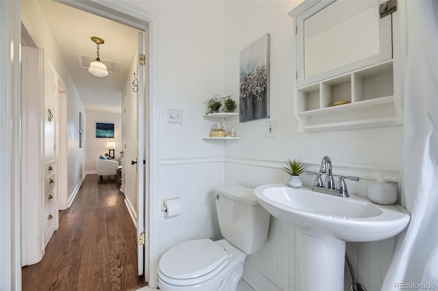 bathroom featuring wood-type flooring, toilet, and sink