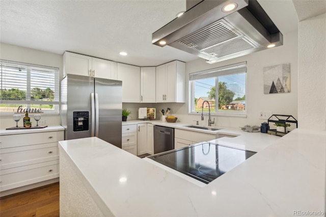 6193 Holland St, Arvada, CO 80004 - kitchen featuring appliances with stainless steel finishes, extractor fan, light countertops, white cabinets, and recessed lighting