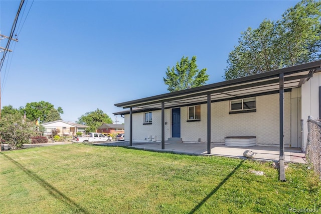 6193 Holland St, Arvada, CO 80004 - rear view of property featuring a lawn and a patio area