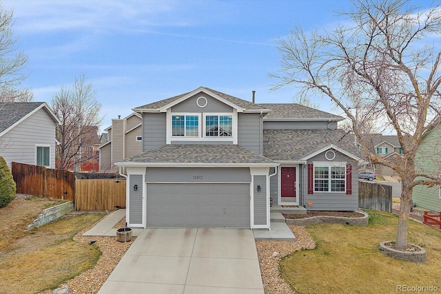 traditional-style home with a shingled roof, a garage, fence, concrete driveway, and a front lawn