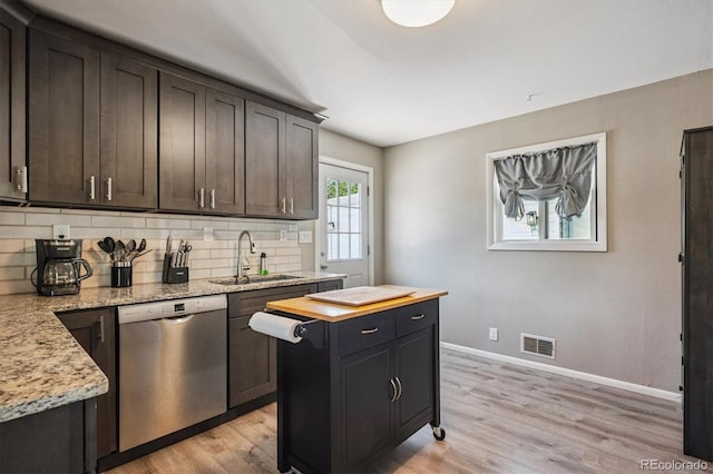 3995 Nelson St, Wheat Ridge, CO 80033 - kitchen featuring stainless steel dishwasher, decorative backsplash, light wood-style flooring, butcher block countertops, and dark brown cabinetry