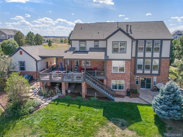 rear view of property featuring a yard and a wooden deck