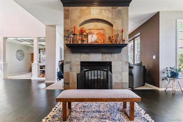 living room with decorative columns, hardwood / wood-style flooring, and a fireplace