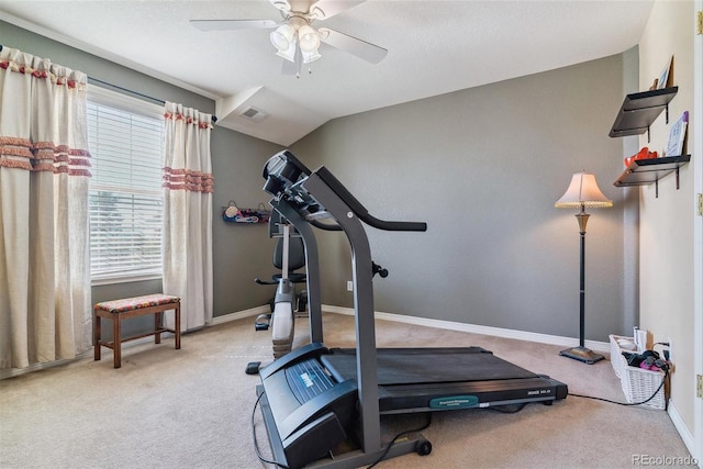 exercise room featuring lofted ceiling, ceiling fan, light carpet, and a textured ceiling