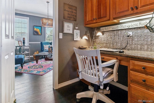 home office with crown molding, dark wood-type flooring, and built in desk