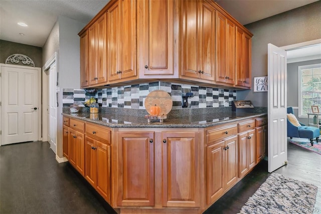 kitchen with dark stone countertops and backsplash