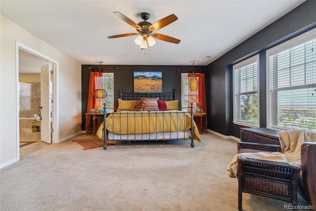 carpeted bedroom with ensuite bathroom and ceiling fan