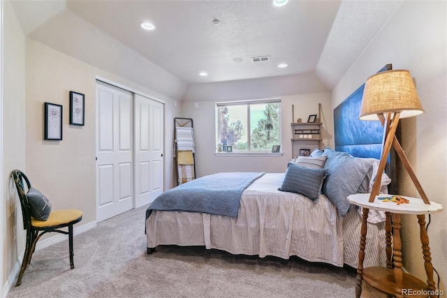 carpeted bedroom featuring a closet and a textured ceiling