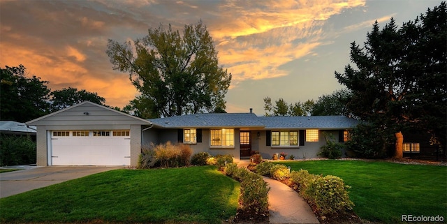 ranch-style home with a yard and a garage