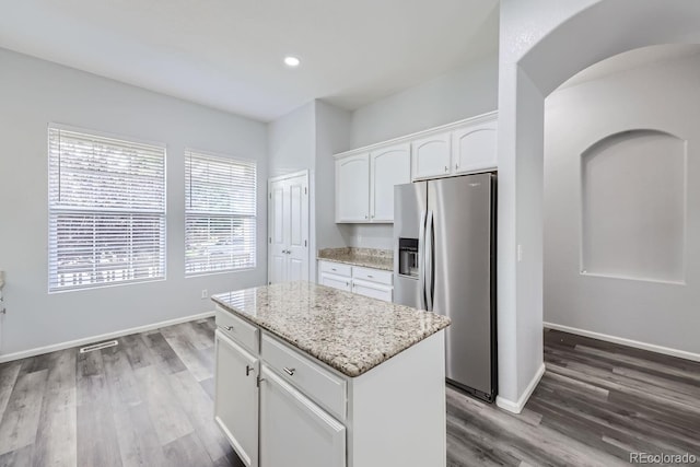 kitchen featuring a kitchen island, white cabinetry, wood-type flooring, light stone counters, and stainless steel refrigerator with ice dispenser