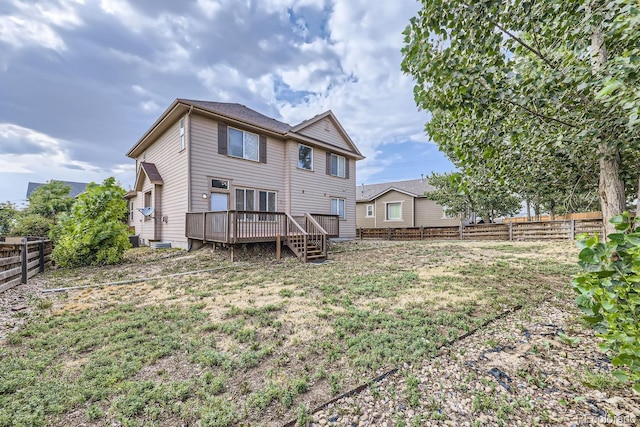 rear view of house with a wooden deck and a yard