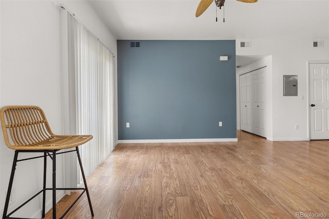 unfurnished bedroom featuring light wood-type flooring, electric panel, and baseboards