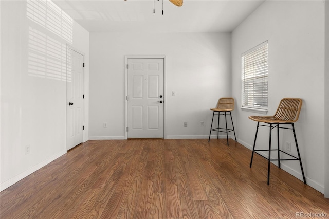 foyer with ceiling fan, wood finished floors, and baseboards