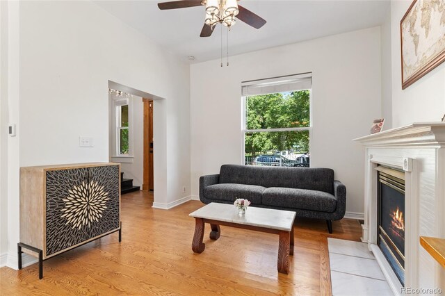 2829 N Franklin St, Denver, CO 80205 - living area with light wood-type flooring, a ceiling fan, a glass covered fireplace, and stairs
