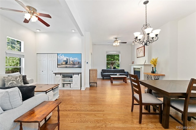 2829 N Franklin St, Denver, CO 80205 - dining room featuring a ceiling fan, light wood-type flooring, a fireplace, and a chandelier