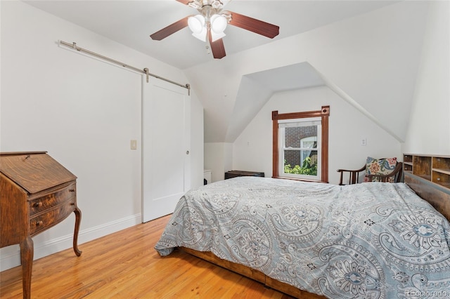 2829 N Franklin St, Denver, CO 80205 - bedroom featuring light wood-style flooring, a barn door, vaulted ceiling, and ceiling fan