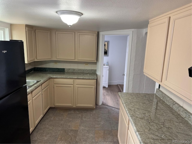 4807 Clayton St, Denver, CO 80216 - kitchen with freestanding refrigerator, a textured ceiling, and cream cabinets
