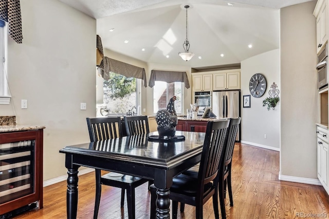 dining room featuring recessed lighting, light wood-style flooring, baseboards, and beverage cooler