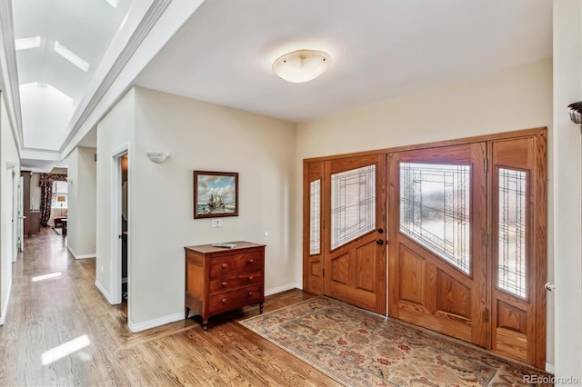 foyer with baseboards and light wood-style floors