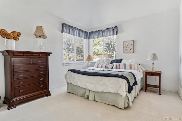 bedroom featuring light colored carpet and baseboards