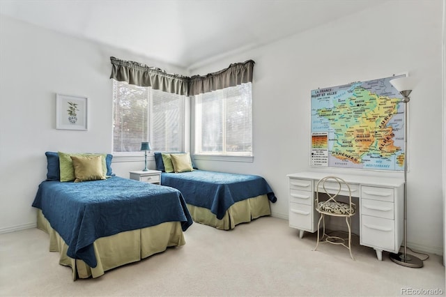 bedroom with light colored carpet and baseboards