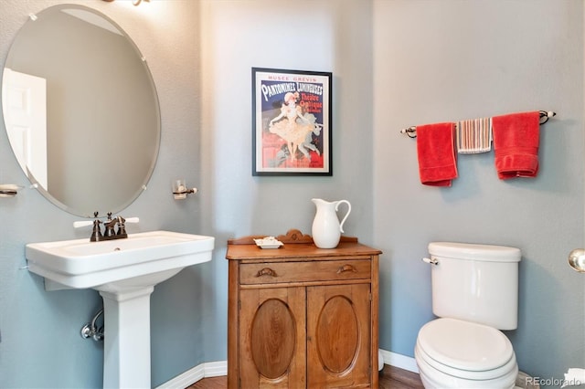 bathroom featuring baseboards and toilet