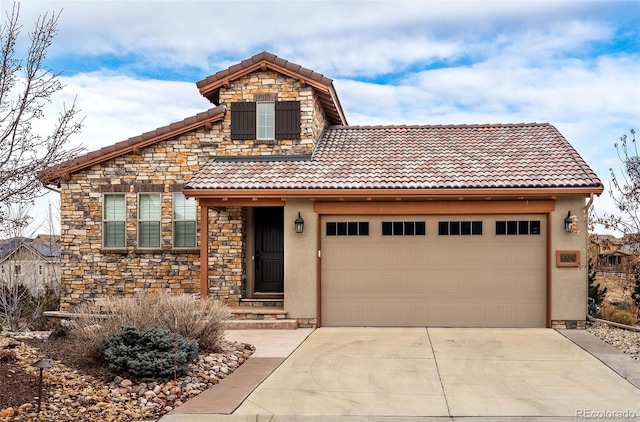 view of front of house with stone siding, a tile roof, driveway, and an attached garage