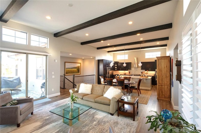 living room with light hardwood / wood-style flooring and beamed ceiling