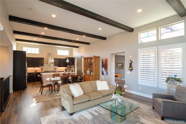 living room featuring beam ceiling and light hardwood / wood-style flooring