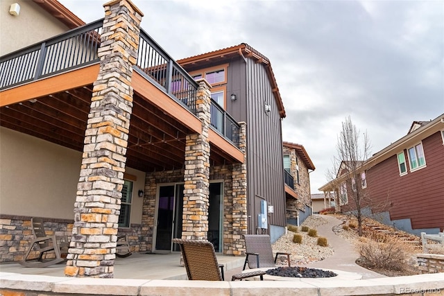 view of side of home featuring a balcony and a patio