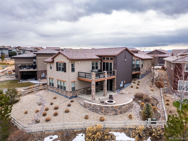 rear view of house with a patio and an outdoor fire pit