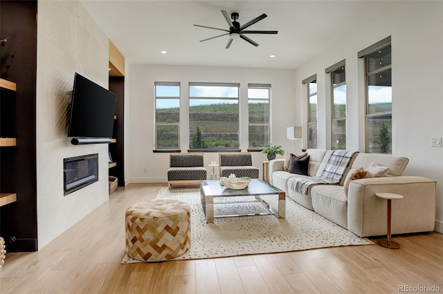 3436 W 154th Ave, Broomfield, CO 80023 - living room with healthy amount of natural light, light wood-style flooring, ceiling fan, a fireplace, and recessed lighting