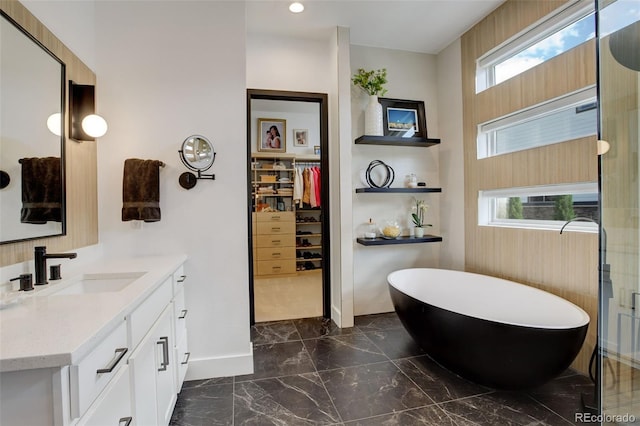 3436 W 154th Ave, Broomfield, CO 80023 - bathroom with marble tiled floors, vanity, a freestanding tub, a spacious closet, and recessed lighting