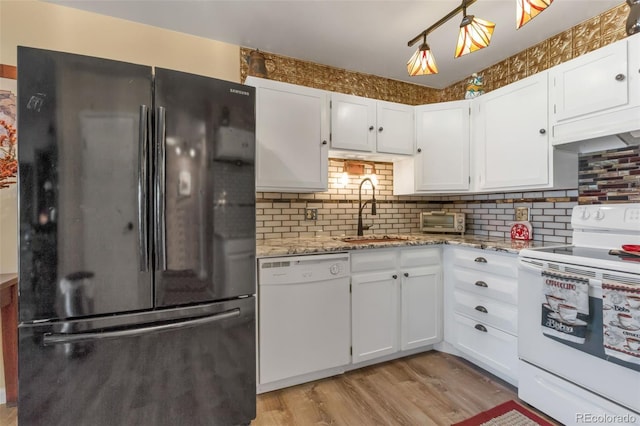 kitchen featuring white cabinets, white appliances, light wood-style floors, and a sink