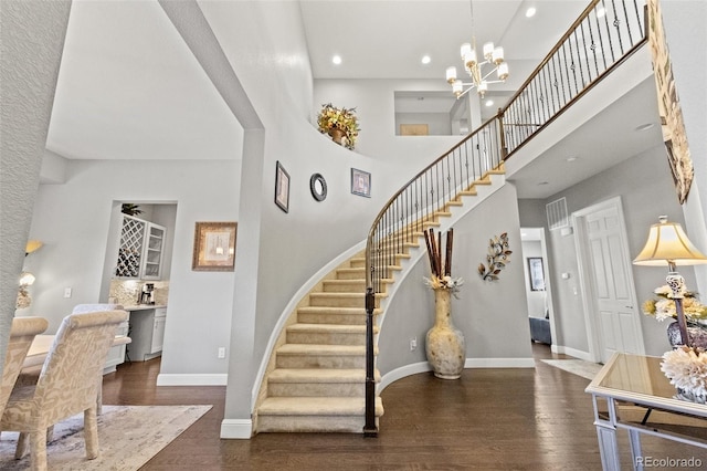 entryway with an inviting chandelier, a high ceiling, and dark hardwood / wood-style floors