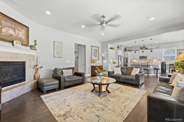 living room featuring a fireplace, dark hardwood / wood-style floors, and ceiling fan