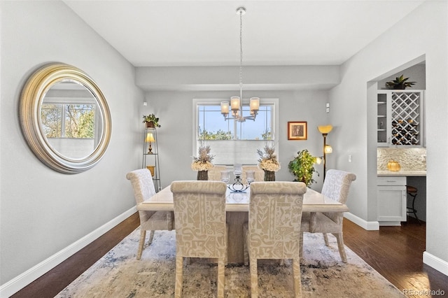 dining room featuring an inviting chandelier and dark wood-type flooring