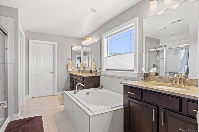 bathroom with vanity and separate shower and tub