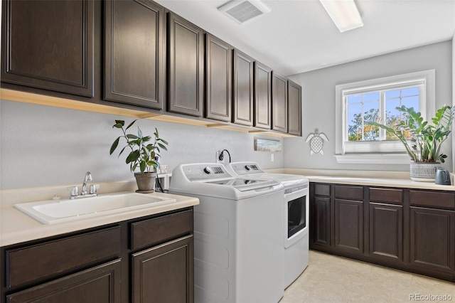 laundry area with cabinets, sink, and separate washer and dryer