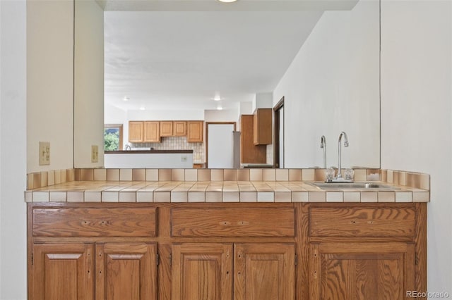 11210 Quivas Loop, Denver, CO 80234 - kitchen featuring brown cabinetry, tasteful backsplash, and a peninsula