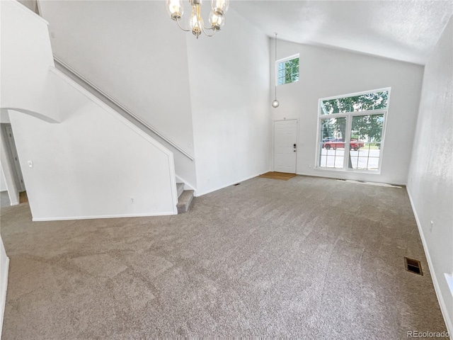 19093 E Linvale Pl, Aurora, CO 80013 - unfurnished living room featuring carpet flooring, stairs, high vaulted ceiling, a chandelier, and arched walkways