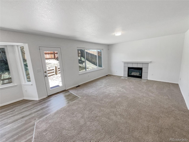 19093 E Linvale Pl, Aurora, CO 80013 - unfurnished living room featuring a fireplace, a textured ceiling, carpet floors, and wood finished floors