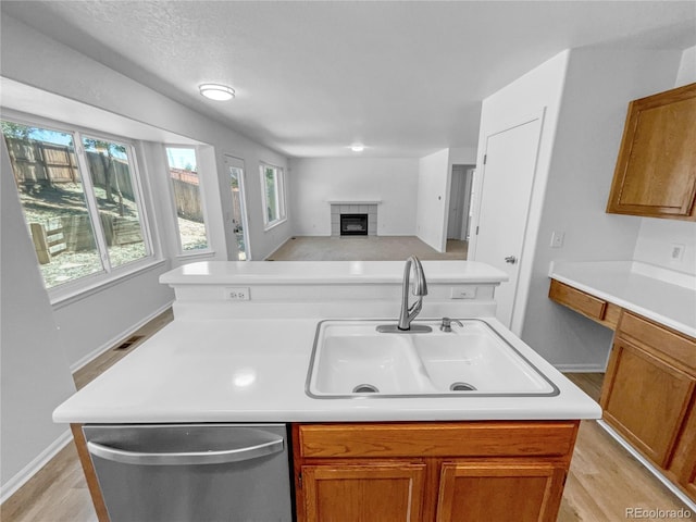 19093 E Linvale Pl, Aurora, CO 80013 - kitchen with dishwasher, a tile fireplace, light countertops, and open floor plan
