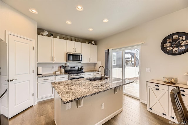 12749 Horton Ct, Parker, CO 80134 - kitchen featuring stainless steel appliances, light wood-style floors, white cabinets, and recessed lighting