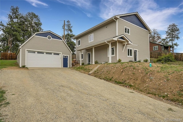 traditional-style home with a garage, an outbuilding, and fence